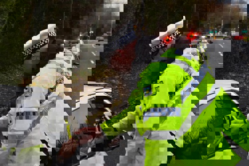 Police officer breath testing a member of the public